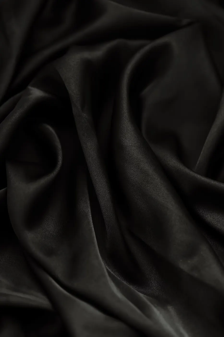 Close-up of black silky fabric with smooth folds